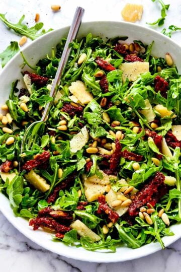 Salad of Arugula featuring Sun Dried Tomatoes and Pine Nuts